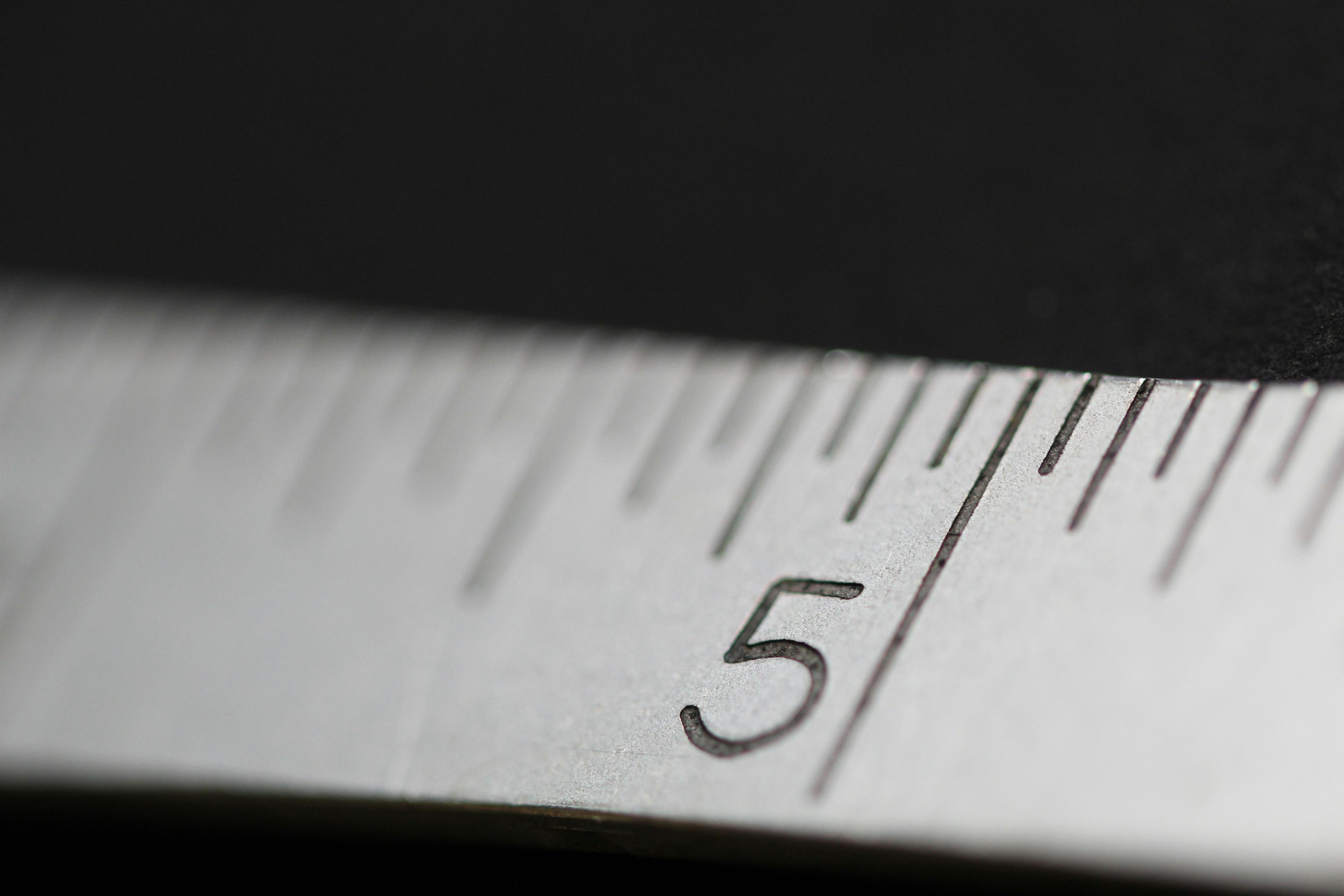 Close-up of a measuring tape at the number 5, in low light