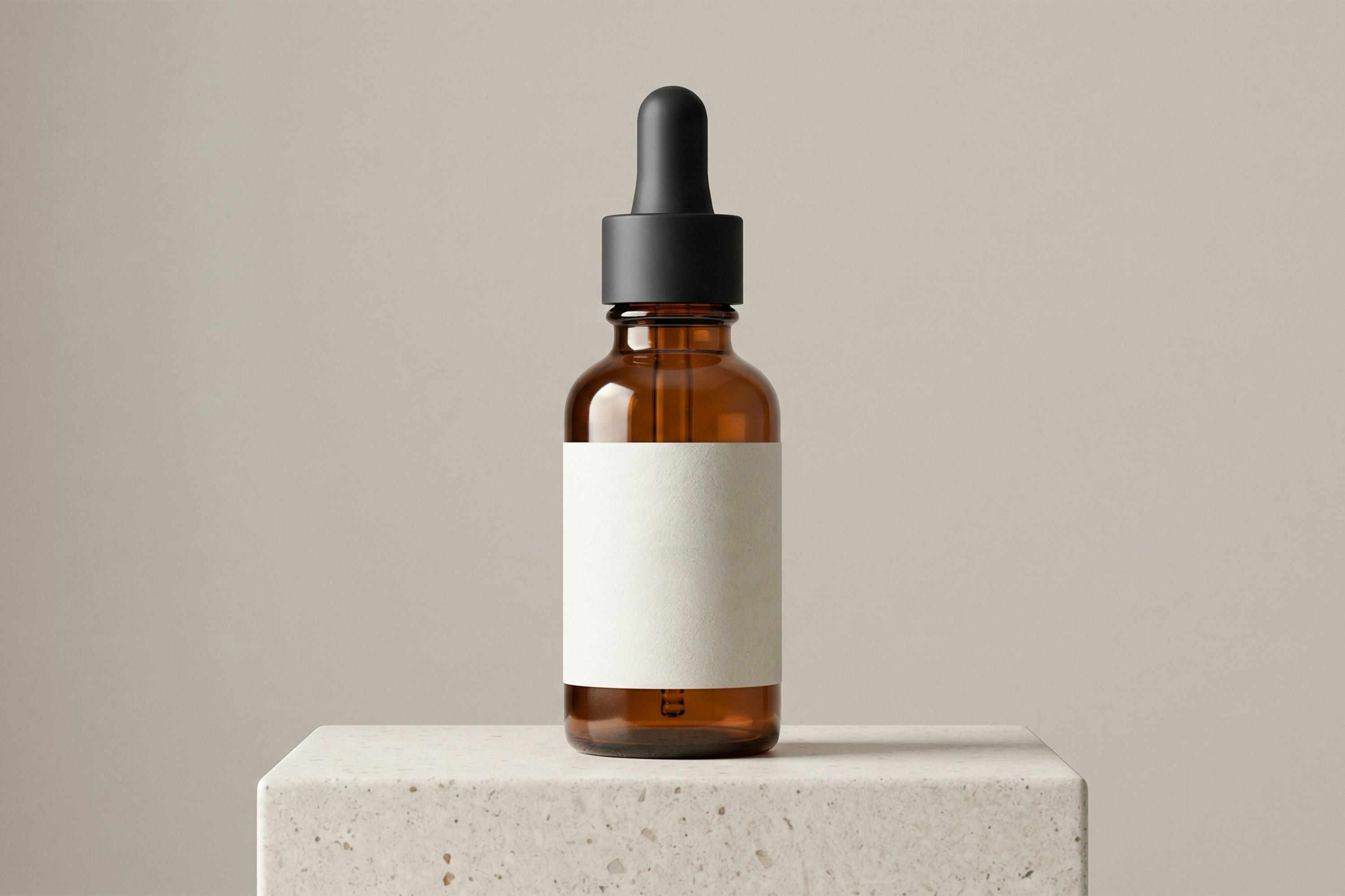 Amber glass dropper bottle with a blank label on a concrete block